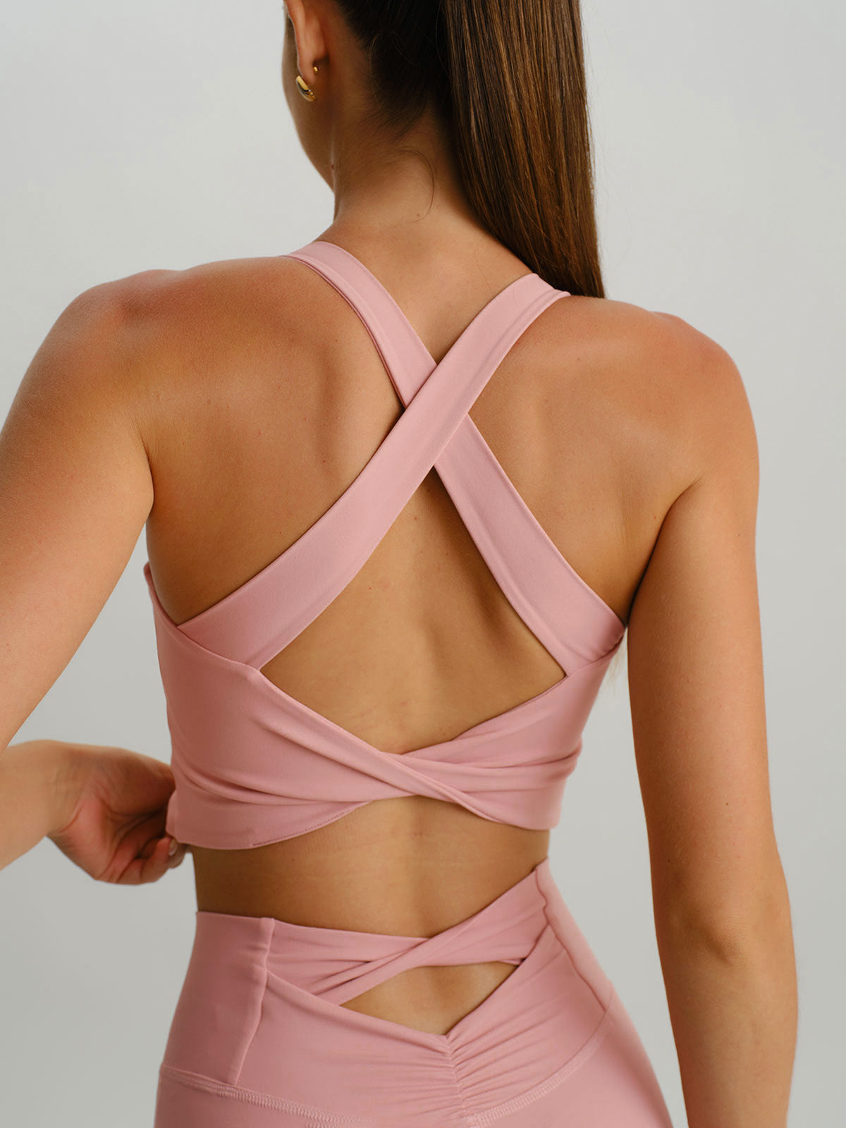 women_s-knitted-nylon-sports-bras-sustainable-yoga_tops-tmzqw3 Light Pink Twist X-Cross Sports Bra - Light Support - Image 1